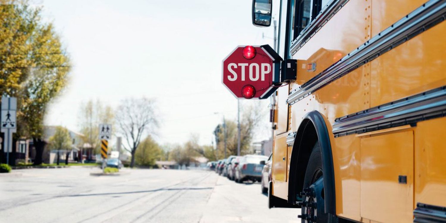 Yellow school bus with extended red stop sign.